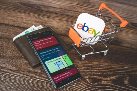 Логотип Ebay в тележке, смартфоне с приложением и кошельком