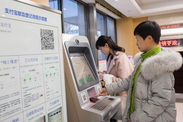 Китайский пользователь мобильного телефона сканирует свою неоплаченную карту донора крови