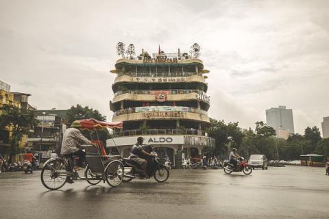 Велосипедисты на фоне торгового центра. Ханой, Вьетнам